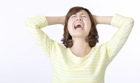 頭を抱えて嘆く女性