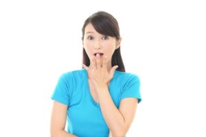 口に手を当て驚く女性