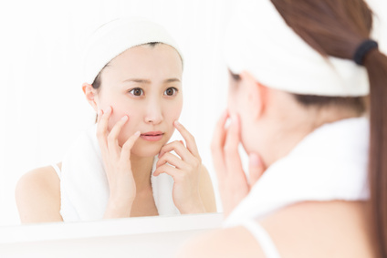 洗顔した肌を鏡で確認する女性