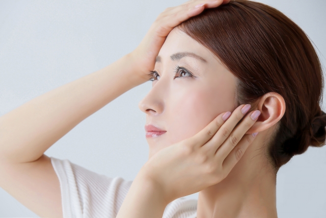 手のひらで顔を覆っている女性の横顔